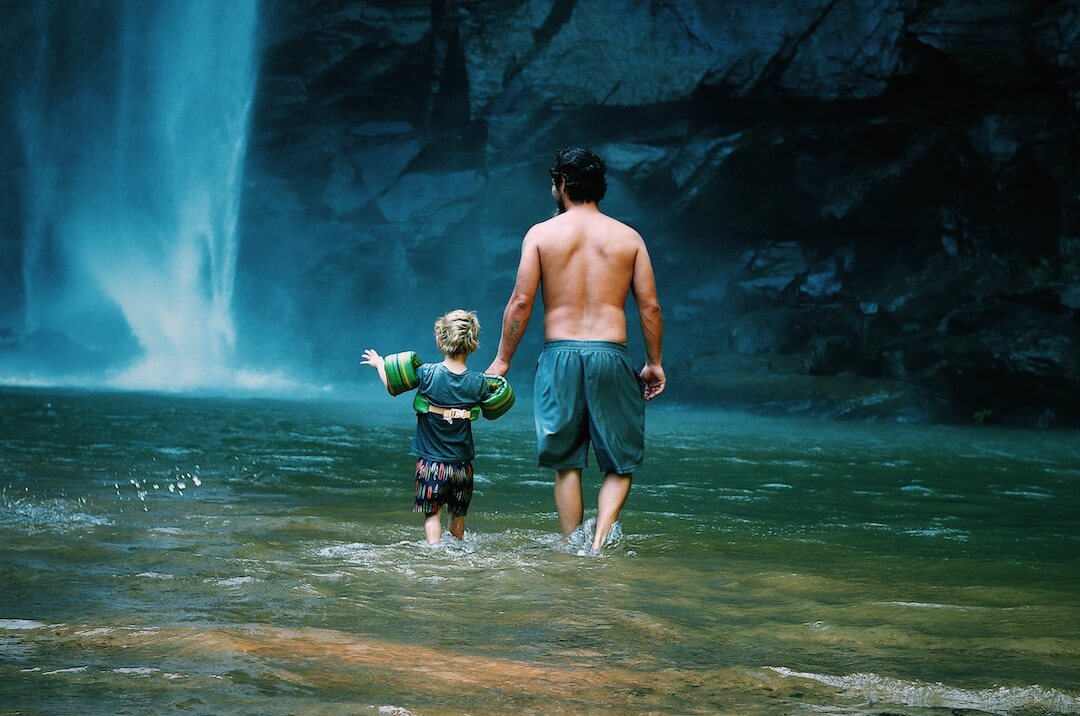 Père et fils se promenant non loin d'une chute